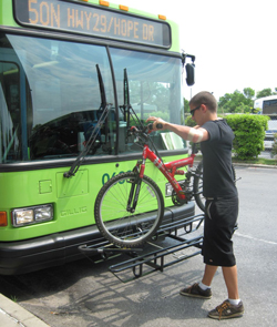Man putting bike on the front of the bus